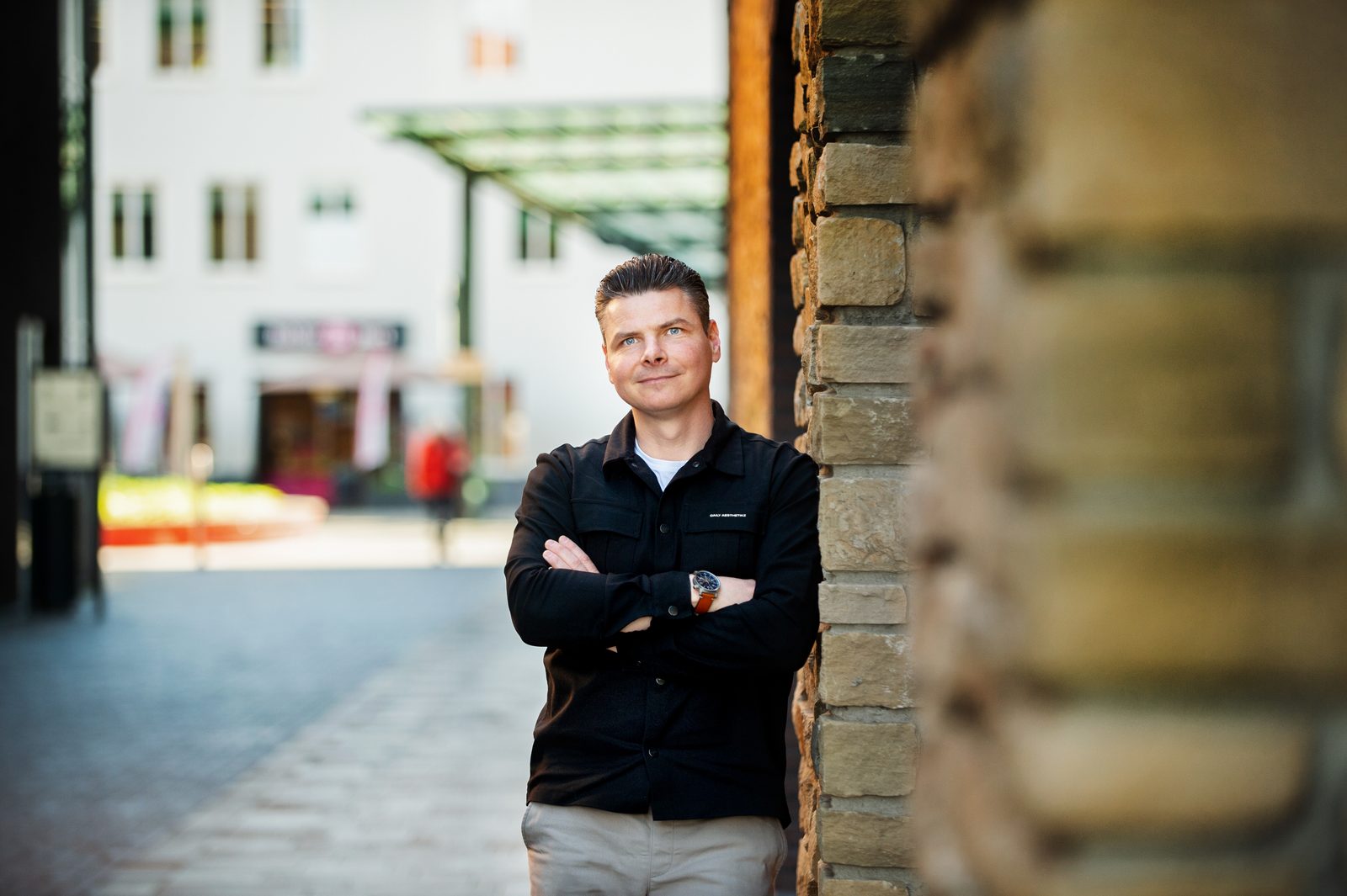 Mark leunend tegen een stenen muur in een stad